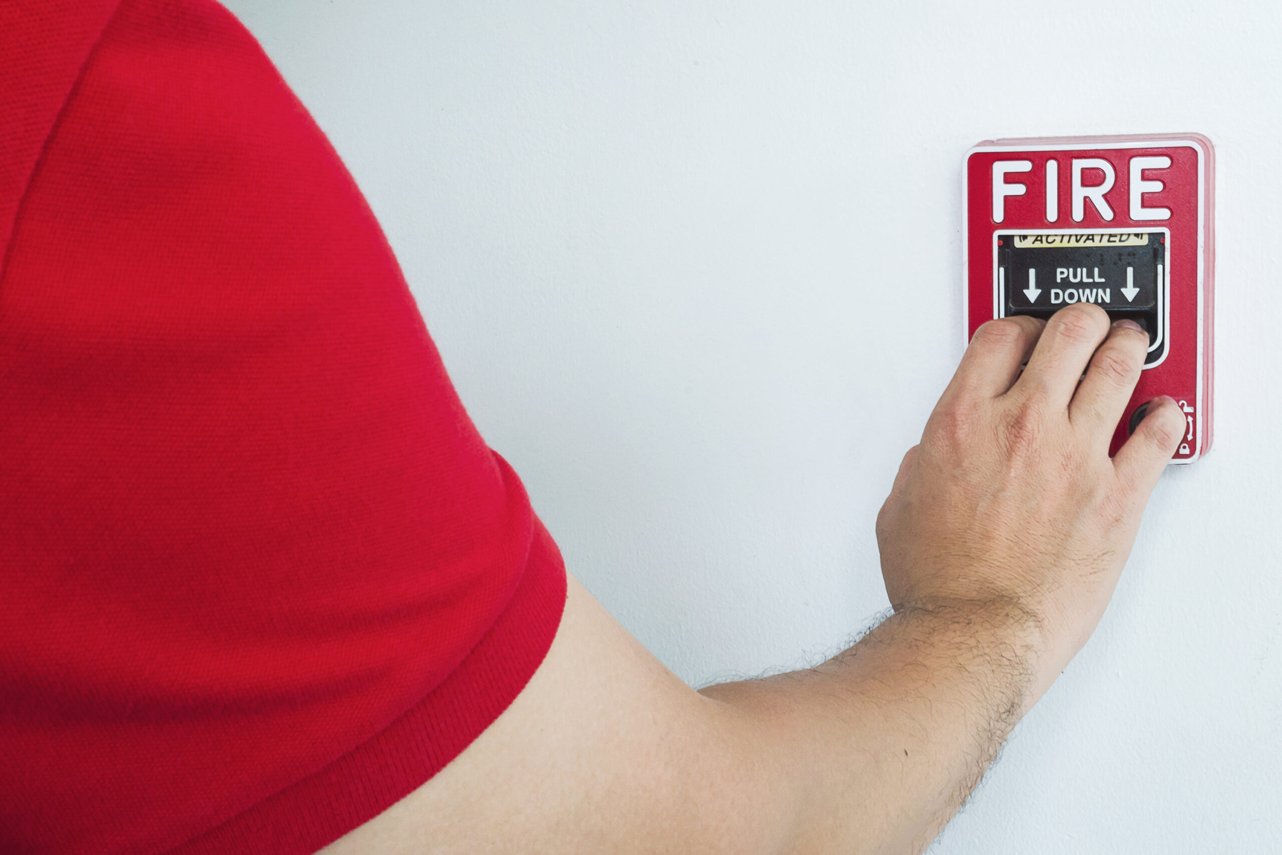 man is reaching his hand push fire alarm hand station scaled